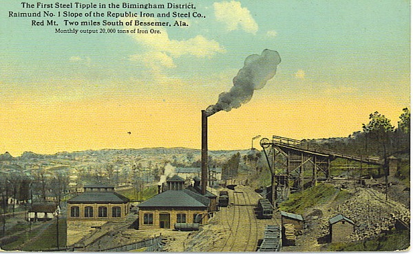 Historical postcard of the first steel tipple in the Birmingham District, featuring industrial buildings and smoke stacks, with a landscape showing tracks and a hillside.